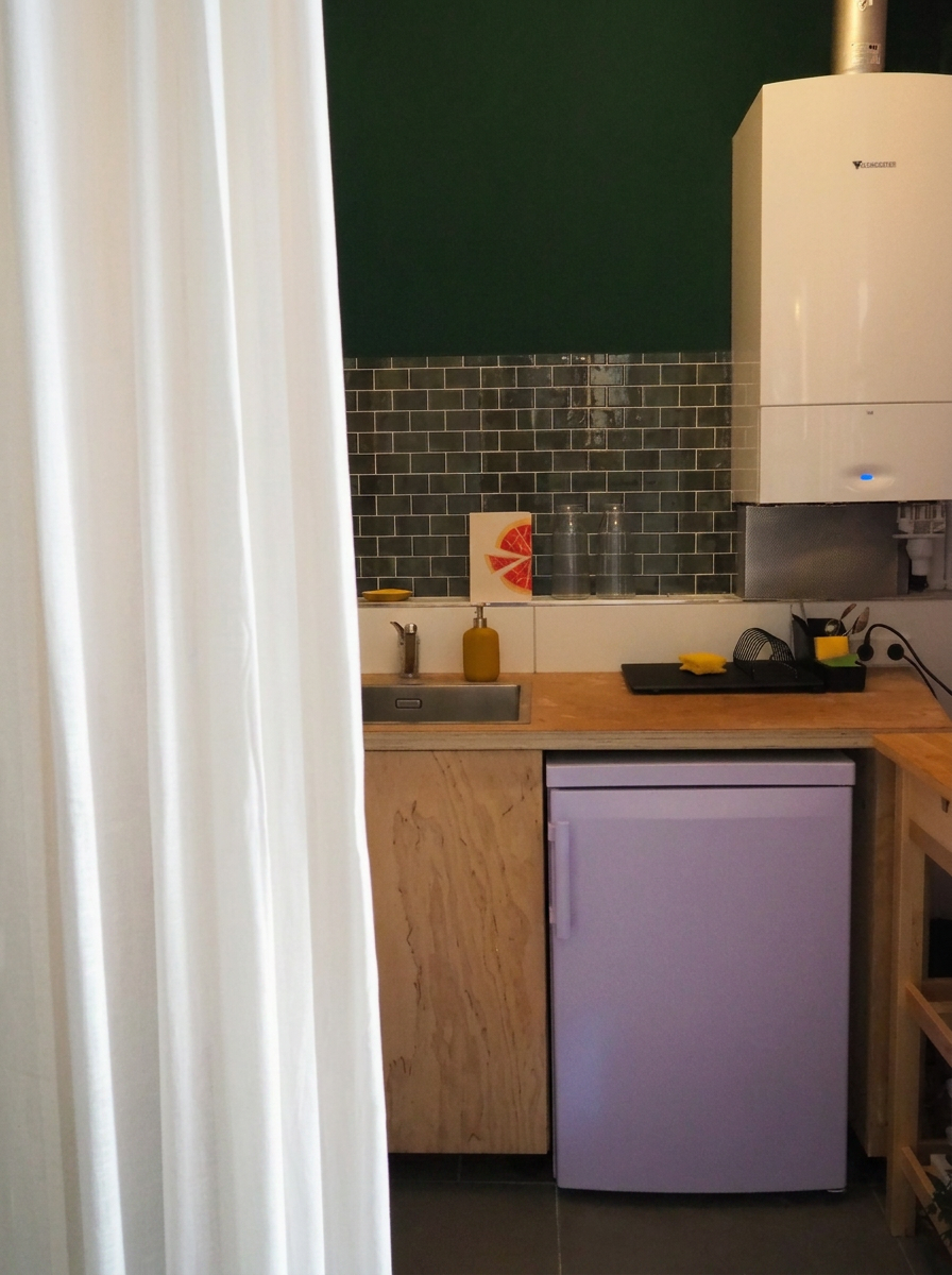Kleine Küche mit dunkelgrüner Wand und lavendelfarbenem Kühlschrank